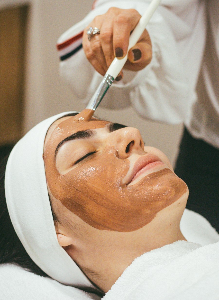 Esteticista aplicando máscara facial em uma cliente