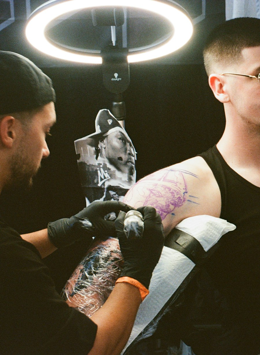 Tatuador trabalhando no braço de um cliente no estúdio